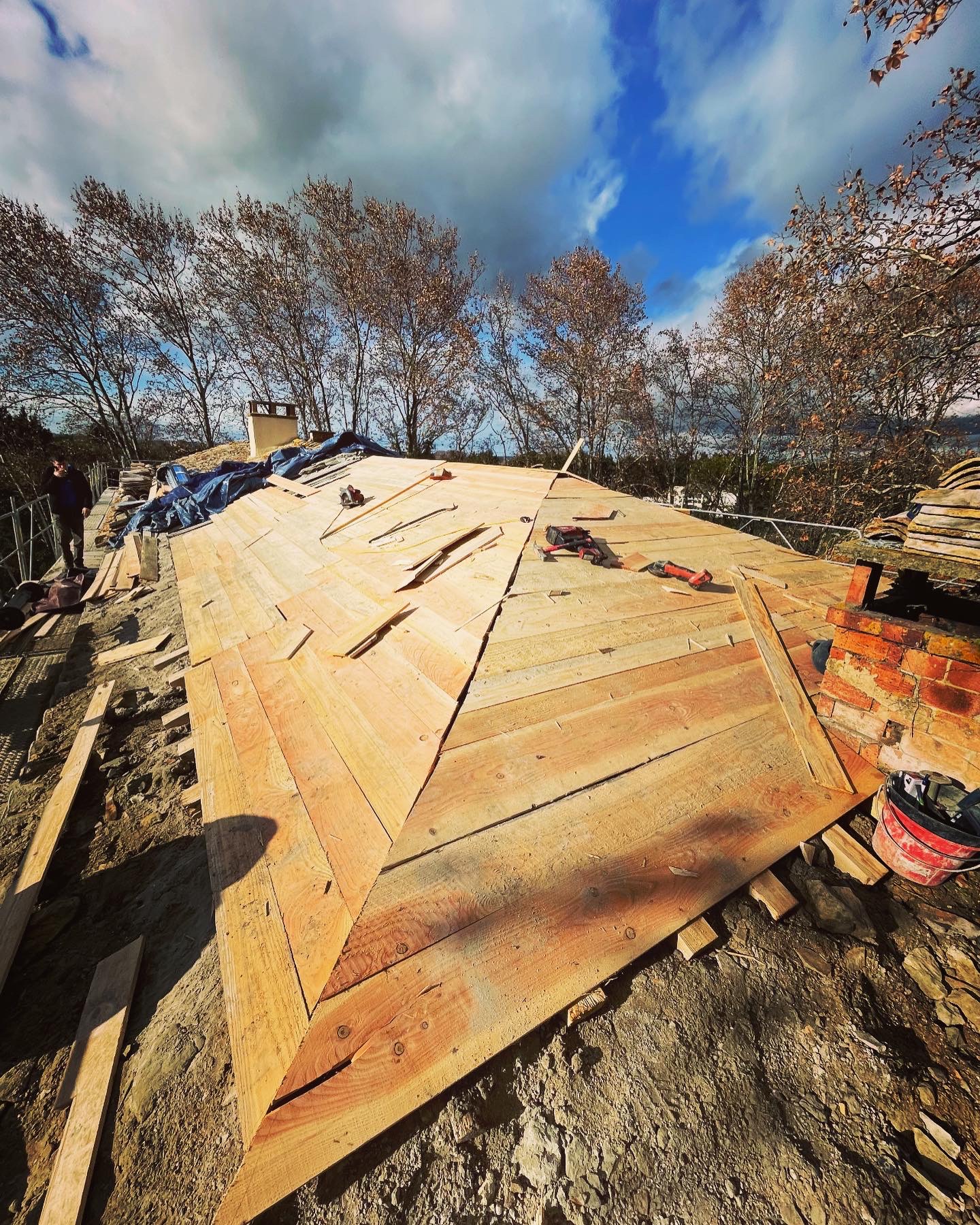 Voligeage neuf en bois posé sur une charpente à quatre pans avant mise en tuiles au Castellet