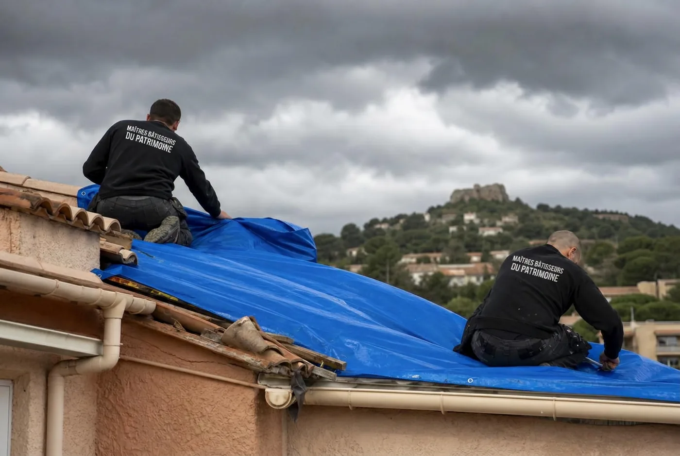 Bâchage d'urgence d'une toiture après tempête à Fréjus par deux couvreurs en pull d'atelier