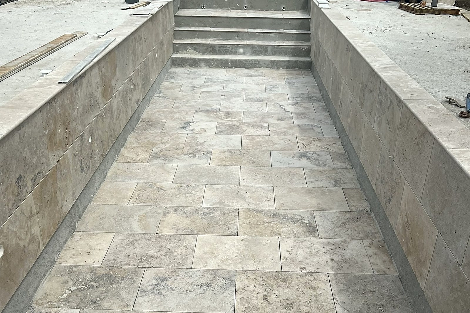 Piscine en travertin en couloir de nage en cours de finition dans le Var